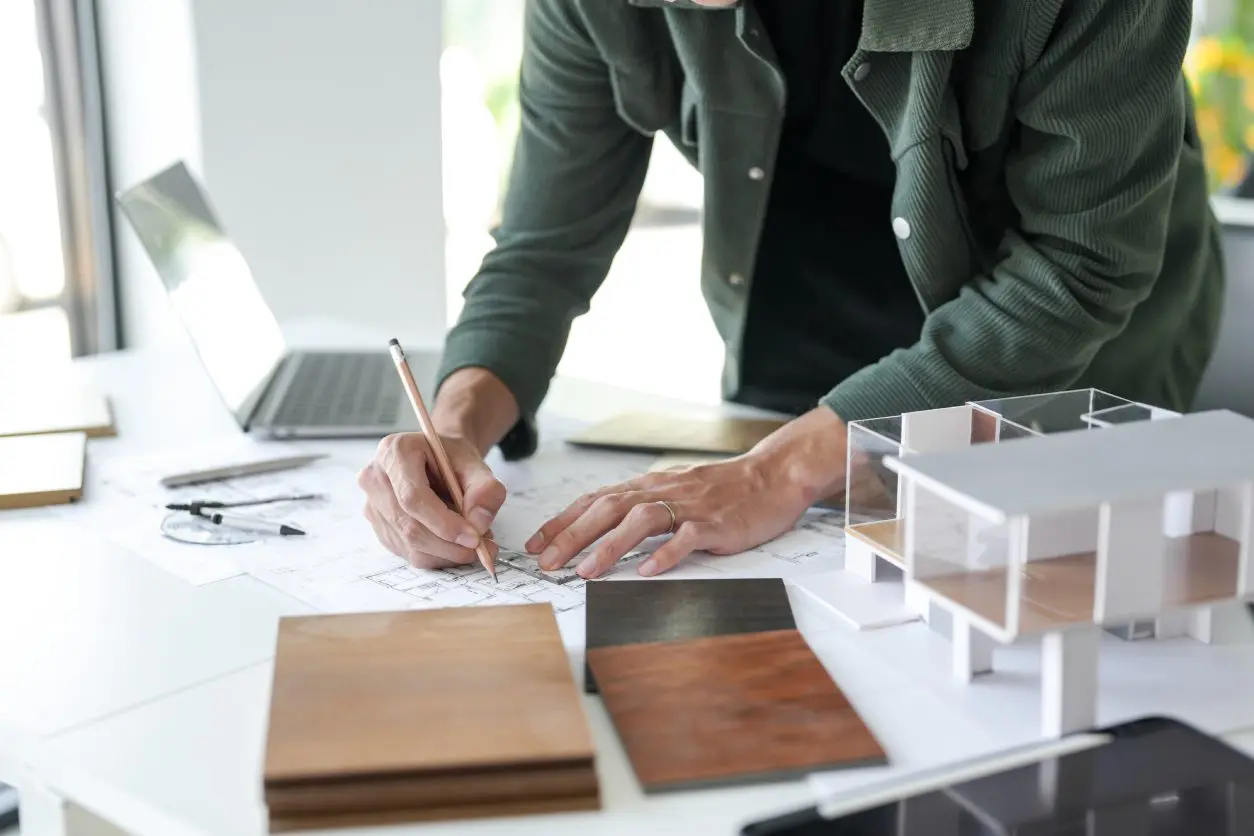Architect designing with model and samples.