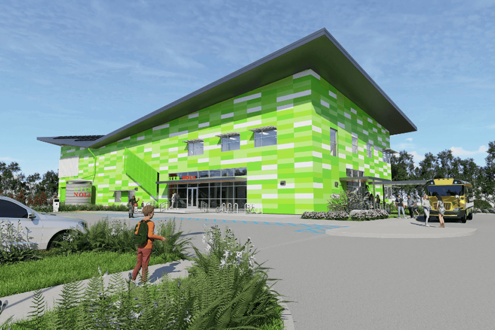 A vibrant green building with a modern design and a person walking nearby.