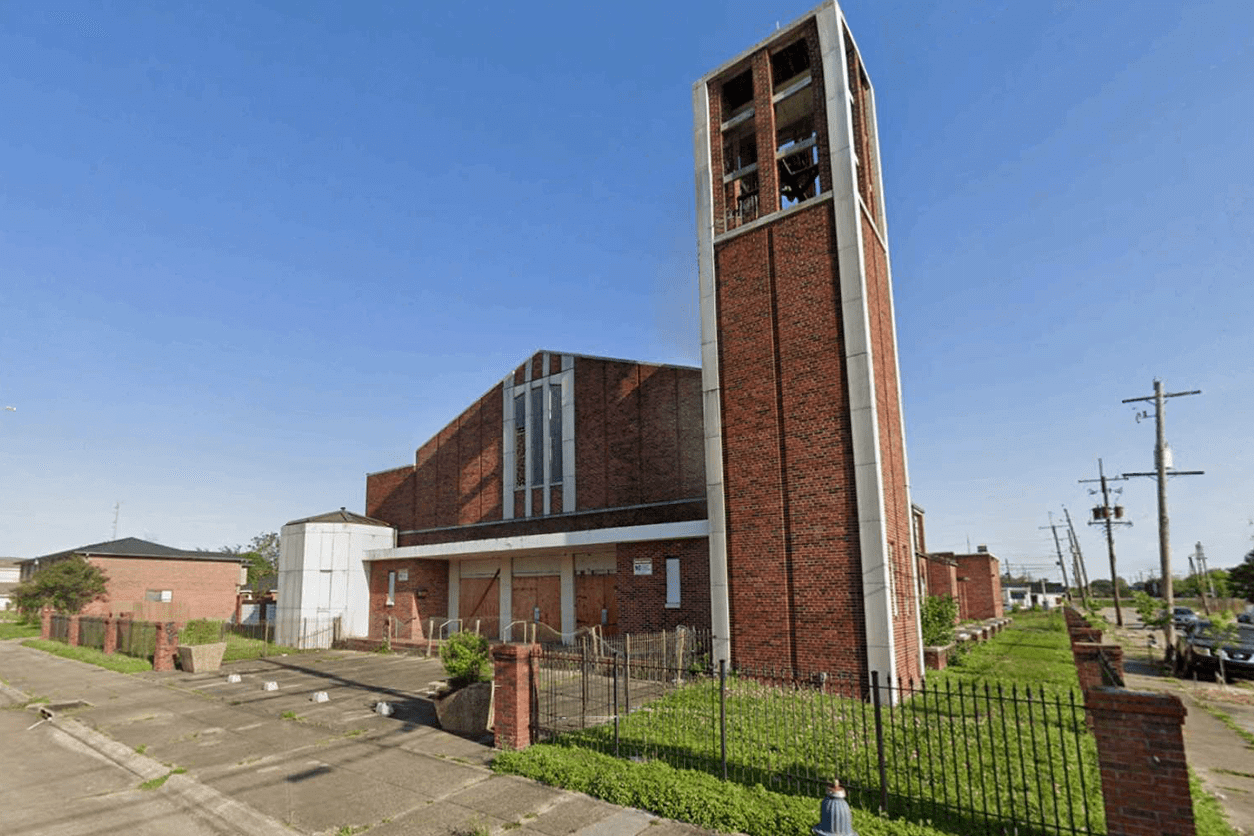 Modern brick church with a tall bell tower under a clear blue sky.